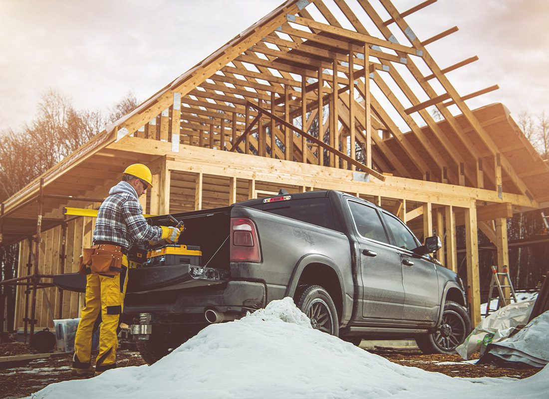Insurance by Industry - Contractor Working on a Wooden House Structure in a Construction Zone